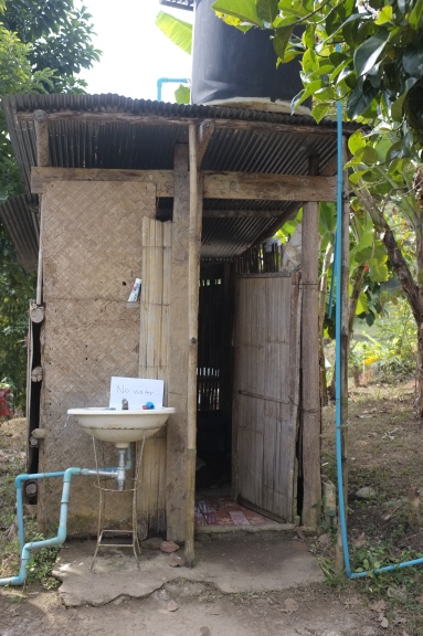 A basic toilet with water storage on the roof.